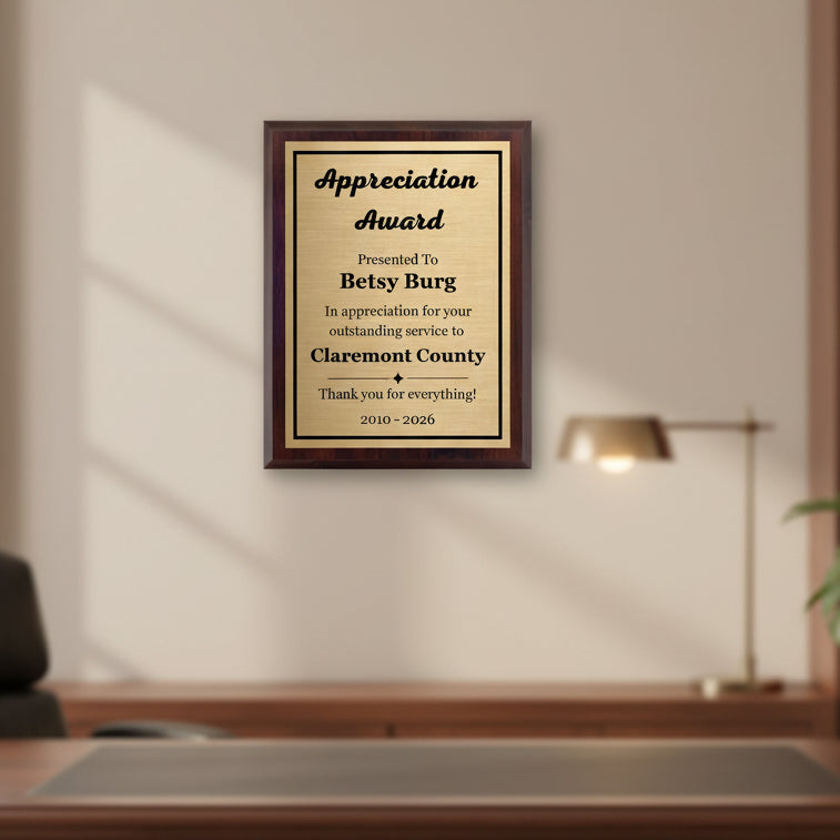Personalized walnut plaque with custom engraving displayed on an office wall
