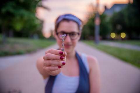 Woman presenting the camera with a flower