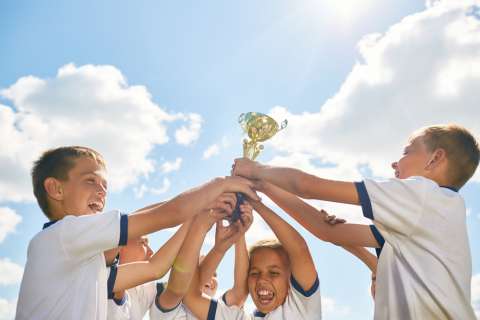 Kids holding up end of the season trophy